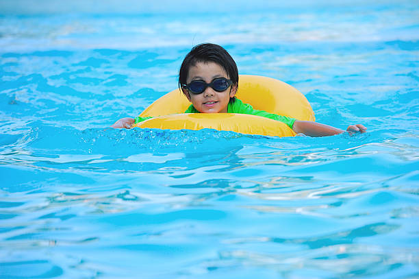 ragazzo asiatico nella provetta imparare a nuotare - swimming tube inflatable circle foto e immagini stock