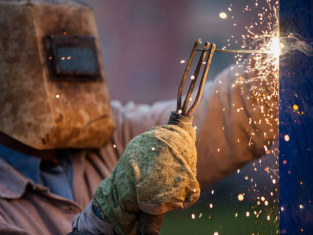 istock Arc welder worker in protective mask welding metal construction 482074266