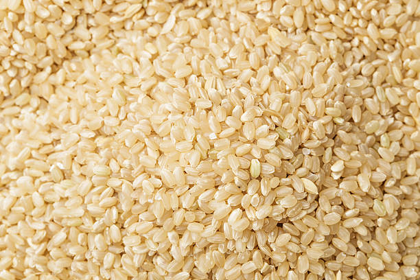 riso integrale - brown rice rice brown scoop foto e immagini stock