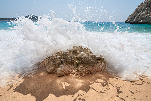 istock Splash of a wave over a rock in the beach 482079898