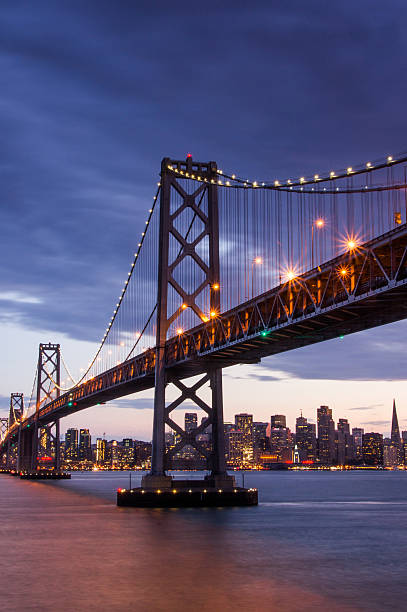 сумерки по мосту bay bridge, сан-франциско - san francisco county san francisco bay area skyline night стоковые фото и изображения