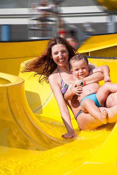 istock child and mom playing with the slide in the pool 482095786