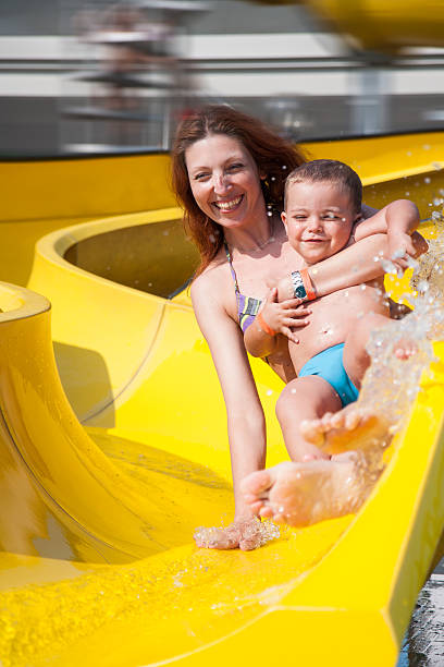 istock child and mom playing with the slide in the pool 482095790