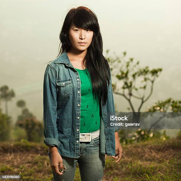 Asian Girl Looking At Camera With Blank Expression In Nature Stock Photo - Download Image Now