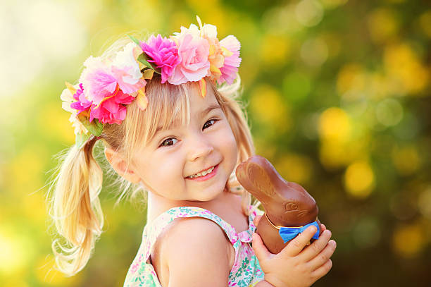 jolie fille avec le lapin en chocolat de pâques - child easter flower little girls photos et images de collection