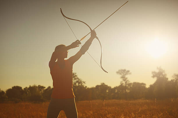 istock Female archer in the field at sunset 482101920