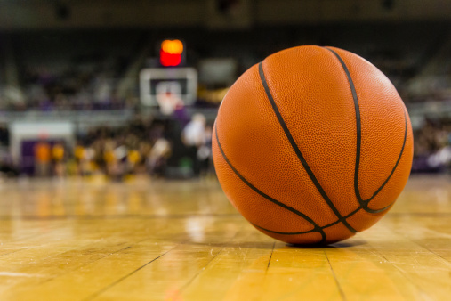 Basketball with spotlight and fade-out shadow in the dark background. Copy space. Sport and game concept. 3D illustration rendering