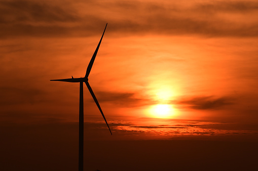 Wind turbines silhouette at sunset.