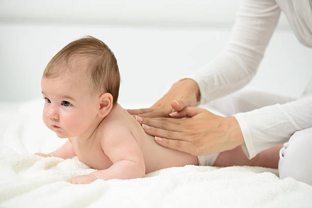 masaż niemowląt - massaging massage therapist rear view human hand zdjęcia i obrazy z banku zdjęć