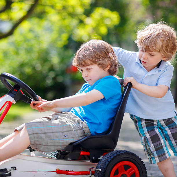 istock Two happy sibling boys having fun with toy car 482105640