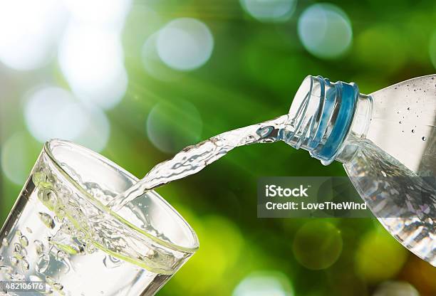 Drinking Water Is Poured From A Bottle Into A Glass Stock Photo - Download Image Now