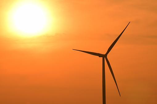 Wind turbines silhouette at sunset.