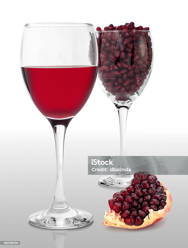 Pomegranate Juice Two glasses of pomegranate juice and seed, with fruit segment beside. 2015 Stock Photo
