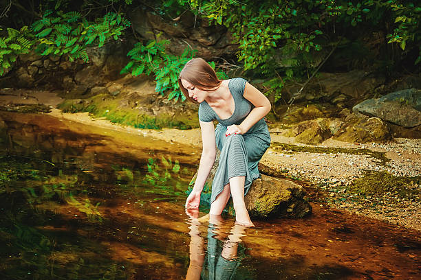 istock Woman sitting on the rock in a pond 482112938