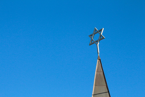 Top of a steeple on a temple that has the Star of David atop it.  The spire is on top of a synagogue in Leadville, Colorado.