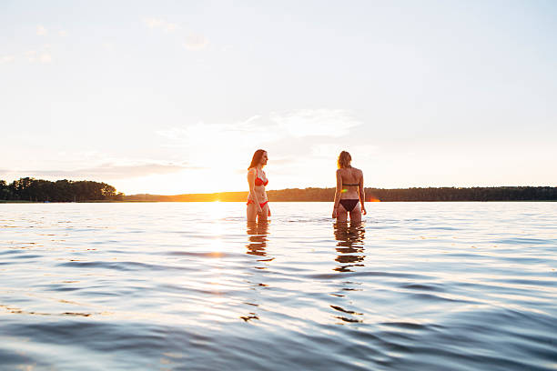 istock carefree summer day: two young woman standing in the lake 482117456