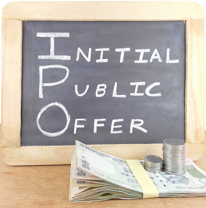 Initial public offer, IPO, concept, indicated through handwritten text on a chalkboard and Indian rupees placed in front of it.