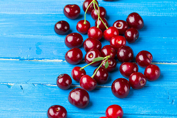 istock Cherries on a blue wooden background 482120368