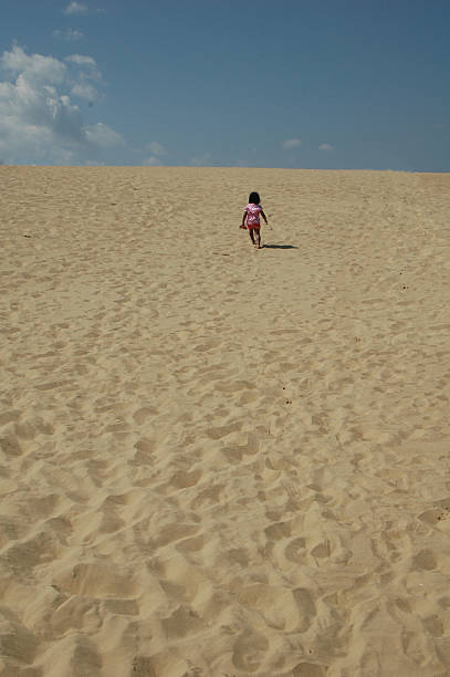 istock Little girl walking in a desert 482123366
