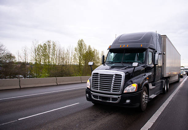 istock Big black modern semi truck rig trailer traffic on highway 482123396