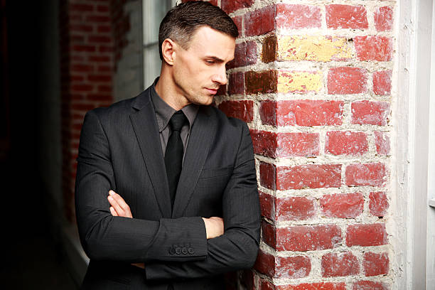 istock Pensive businessman standing with arms folded 482124345