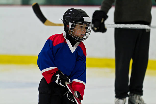 istock Child ice hockey player at practice with coach watching on 482125145