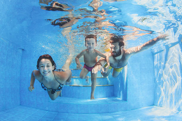 happy family with children swimming with fun in pool - baby swim under water bildbanksfoton och bilder