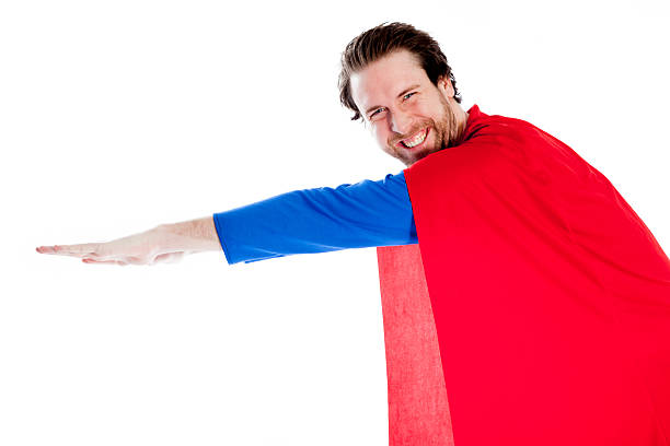 30 years old caucasian man disguised as superman isolated on gray.