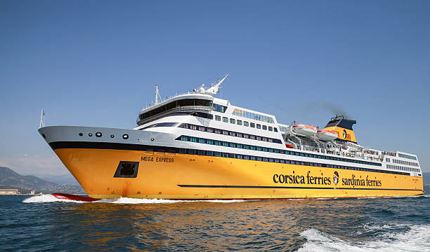 Golfo Aranci - Sardinien - Italien - 02-24-2025: Large Corsica Sardinia ferry is docked at a harbor, showing its yellow hull, upper decks, and mountainous coastline in the background.