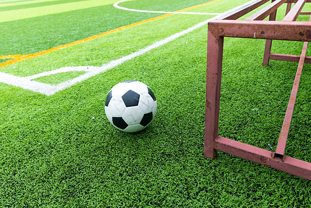 Soccer ball on field and football substitutes seats stock photo