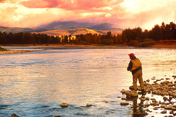 Damon Fishing on the Big Blackfoot River in Montana Damon flyfishing on the Blackfoot River near Missoula, Montana with a storm threatening in the background. fly fishing stock pictures, royalty-free photos & images