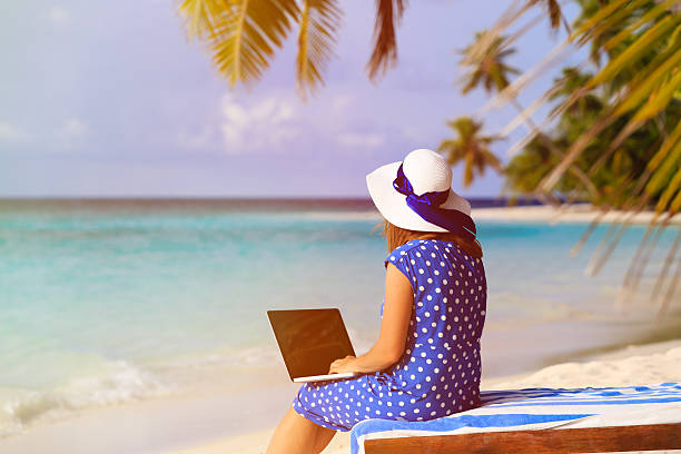 istock young woman with laptop on tropical vacation 482140738
