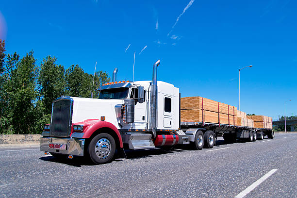 istock Big rig classic semi truck flat bed trailers carry lumber 482147526