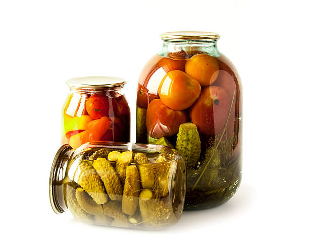 Salted cucumbers and tomatoes in glass jars isolated on white