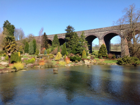 Image of Mill Pond in the gardens of Somerset, England, UK with viaduct arches in the background