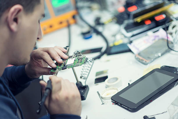 techniker arbeiter weichlöten elemente und reparatur von smart phone - electronics industry circuit board capacitor tweezers stock-fotos und bilder