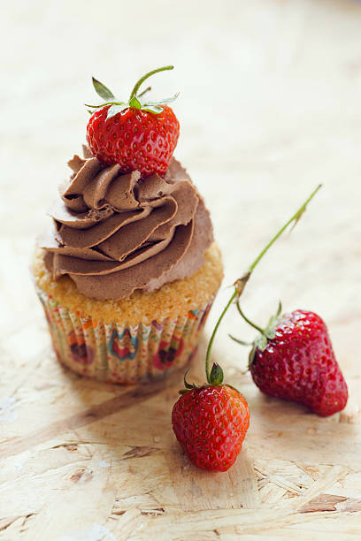 istock Vanilla cupcake with chocolate butter cream icing and fresh strawberries 482170598