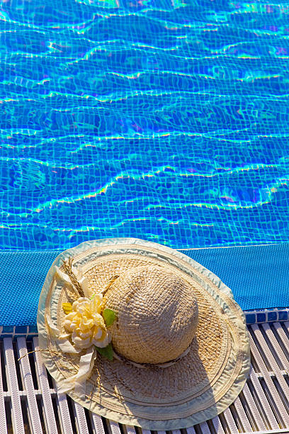 istock The straw hat lies on  brink of pool 482180542