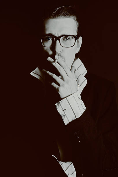 istock Man in glasses with cigarette on black background 482182140