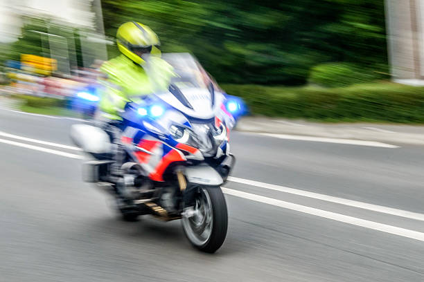 Haastrecht, The Netherlands - July 5, 2015: Police motorcycle cop driving by at high speed through the village of Haastrecht in The Netherlands. The motorcycle is a BMW K1600GT that is the standard motorcycle for the Dutch police force.