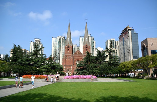 Shanghai, China - July 19, 2015: St. Ignatius Cathedral, also called Xujiahui Cathedral, a Neo-Gothic cathedral, located in Xujiahui district, Shanghai, The church is overlooking a nice ornamental garden. People sightseeing the site.