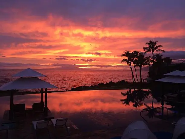 Colorful Maui Sunset reflecting in infinity pool.