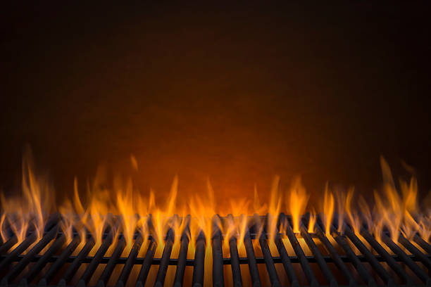 Flaming Hot Barbecue Grill Flaming Hot Barbecue Grill and a Glowing Amber Background metal grate stock pictures, royalty-free photos & images