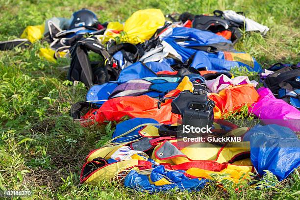 Bright Parachute Lying On Grass With Helmet And Extreme Camera Stock Photo - Download Image Now