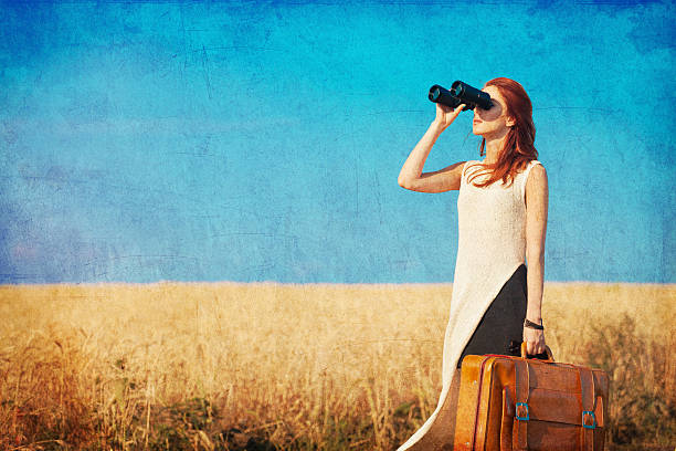 istock girl with suitcase and binocular at countryside road 482188980