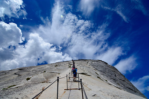 Yosemite, USA - July 7, 2015: Yosemite National Park, Hikers climbing down half dome on a sunny day