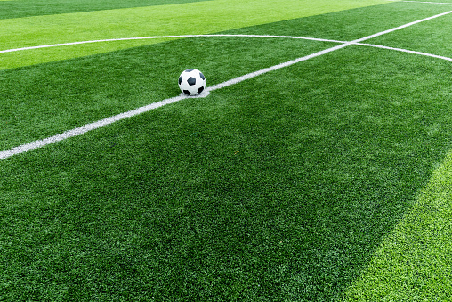 soccer field grass with ball at kick off point.