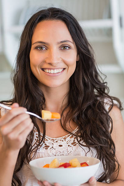 istock Pretty brunette eating fruit salad 482193808