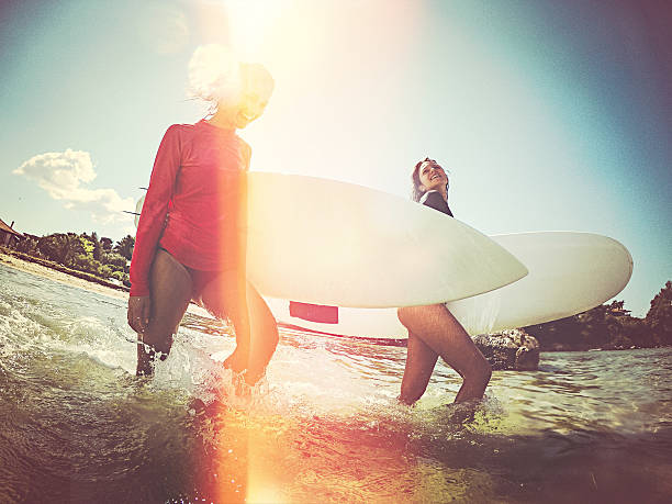 istock Surfer girls walking through the water 482195926