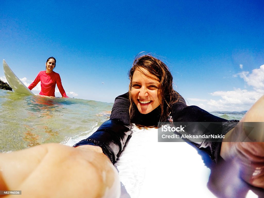 Surfer girls making a selfie Surfer girls are making a selfie, while being on the surfboard Surfing Stock Photo